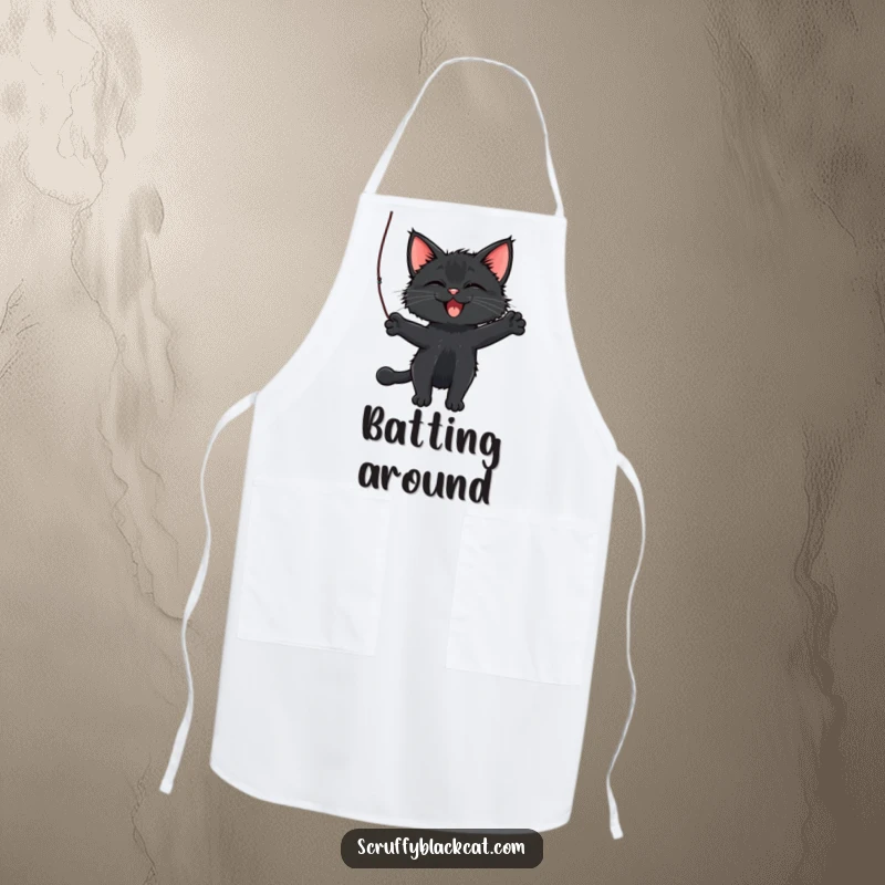 Funny Cat Apron showing a scruffy black cat batting a dangling string, perfect for adding playful humor to cooking.