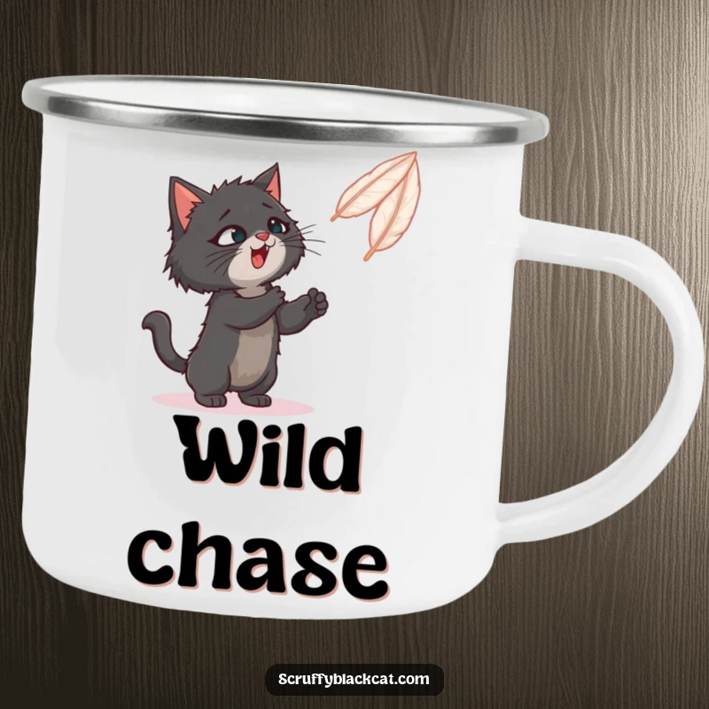 Funny camping mug with a black cat playfully swatting at a feather toy in a wilderness setting.
