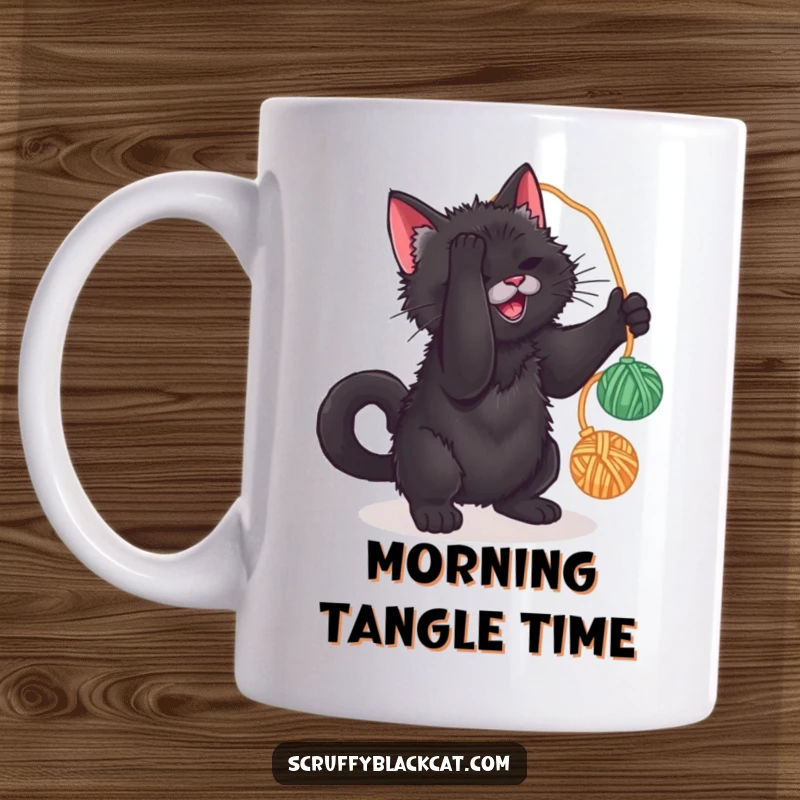 Funny mug showing a scruffy black cat playfully batting at a dangling ball of yarn, full of feline mischief.