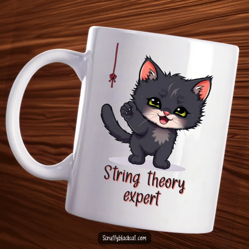 Funny mug showing a scruffy black kitten gleefully batting at a dangling string, captured mid-playful pounce.