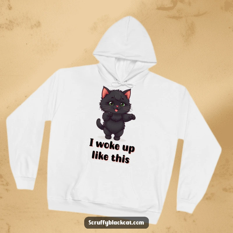 Funny fluffy black kitten doing an exaggerated, playful stretch on a warm, comfortable hoodie.
