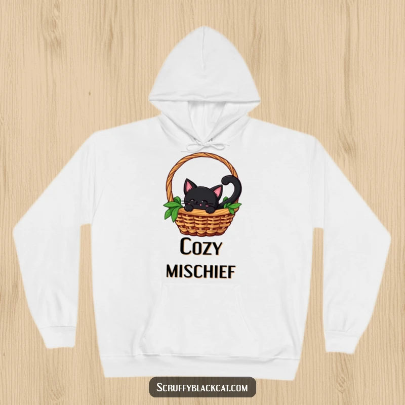 Funny hoodie showing a black cat with a swishing tail peeking out from the confines of a wicker basket, embodying playful mischief.