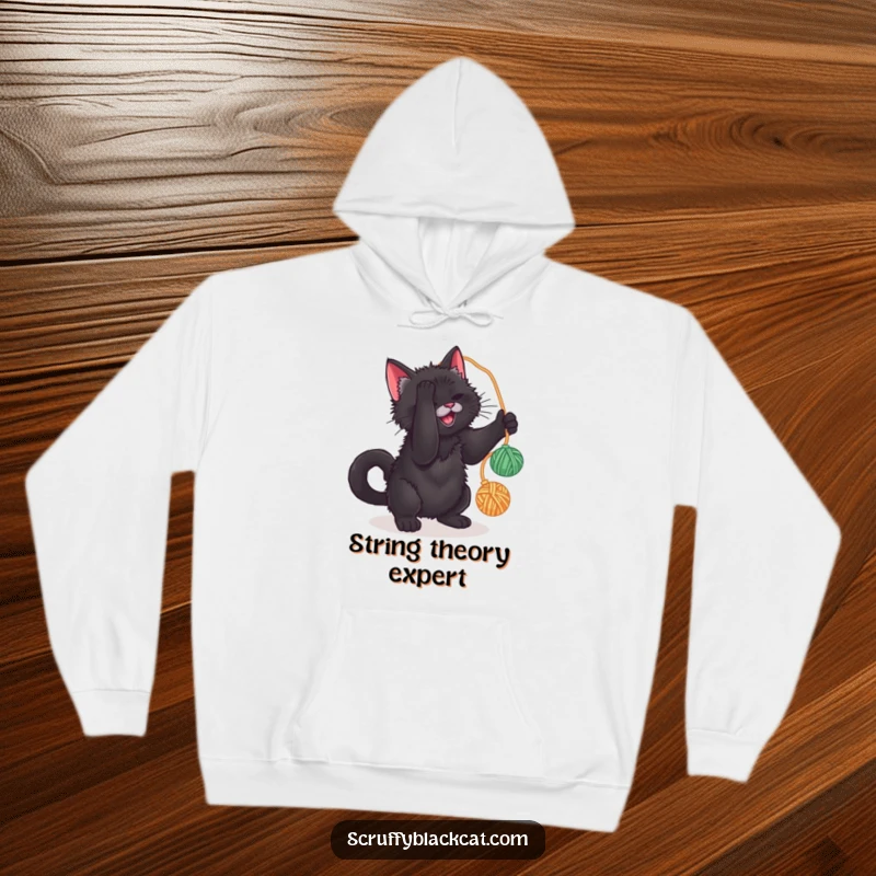 Funny hoodie with a scruffy black cat caught mid-play, batting at a yarn ball, offering warmth and humorous charm.