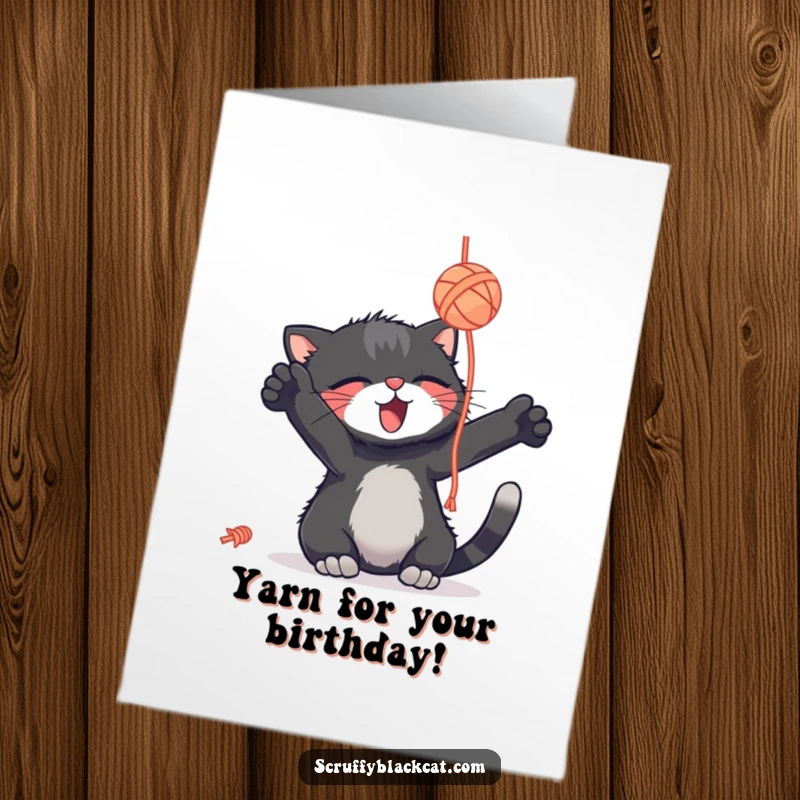 Funny free printable birthday card: a scruffy black cat playfully bats at a dangling yarn ball with pure delight.