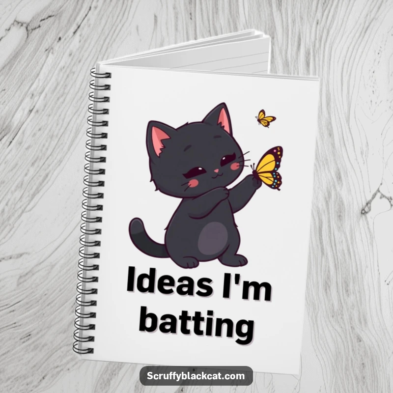 Funny black cat playfully swatting at a butterfly, featured on the cover of a notebook, inspiring creative thoughts and playful journaling.