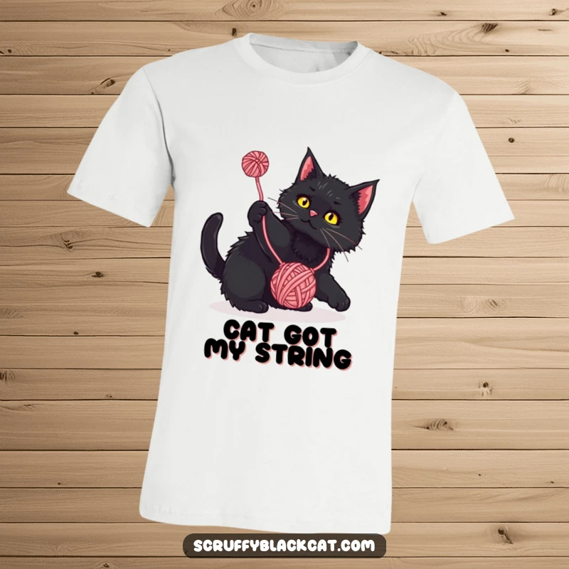 Funny T-Shirt: Scruffy black cat playfully batting at a dangling yarn ball, a humorous and adorable tee for cat lovers.