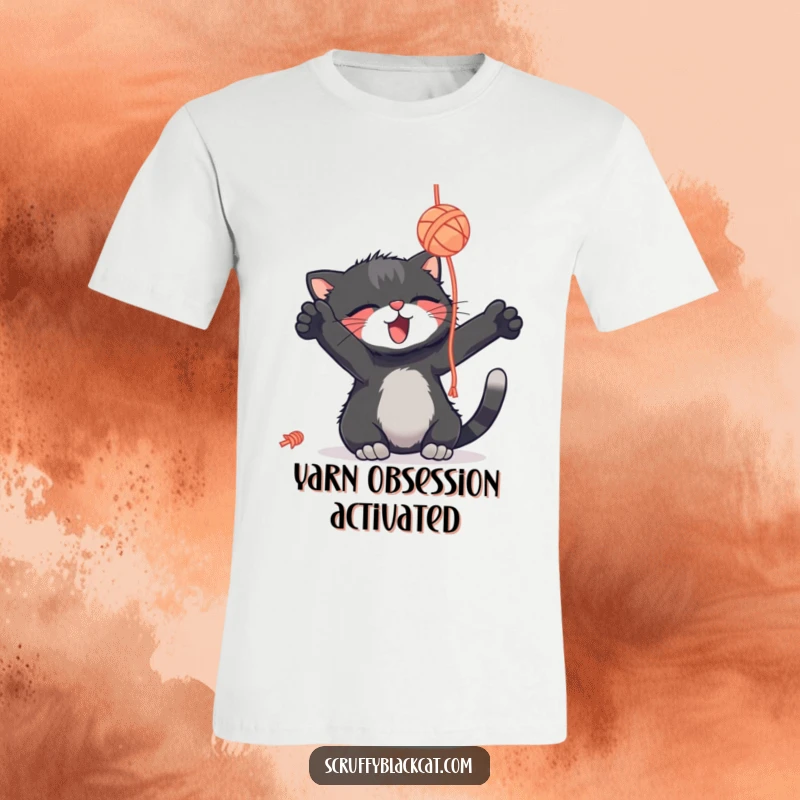 Funny scruffy black cat t-shirt, batting a dangling yarn ball with delight, a playful and humorous graphic tee.