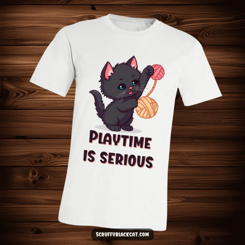 Funny kitten t-shirt showcasing a scruffy black kitten batting playfully at a dangling yarn ball, a humorous and adorable design.