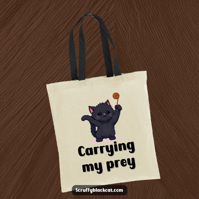 Funny kitten tote bag showing a scruffy black kitten playing with a ball of yarn, highlighting active fun.