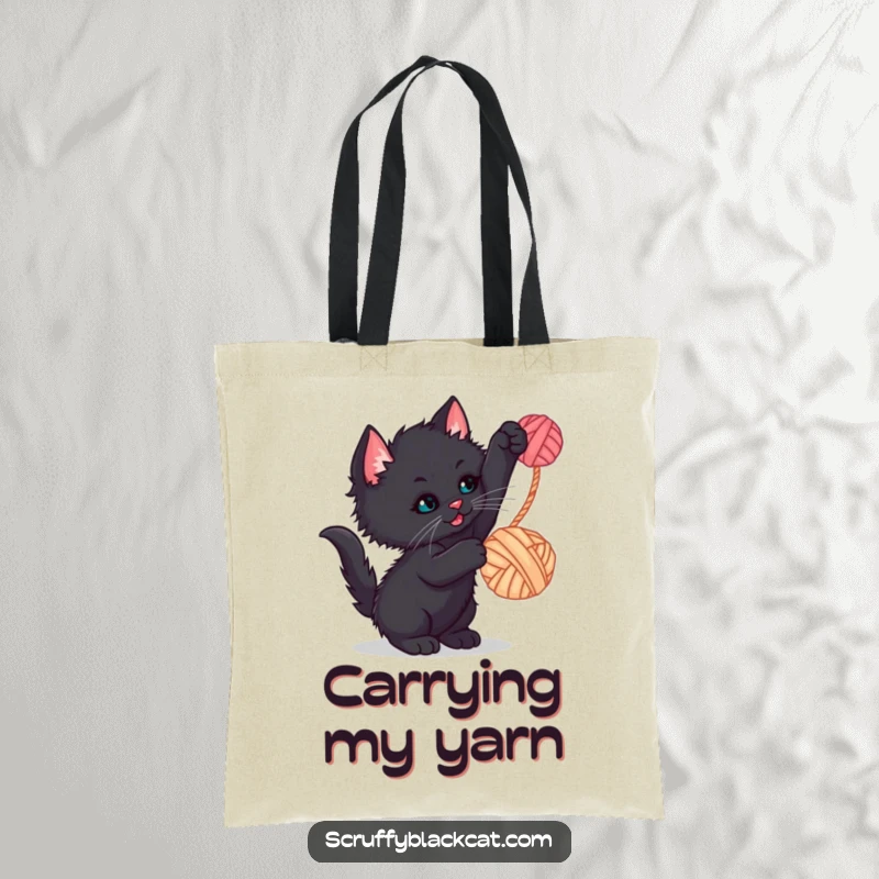 Funny kitten tote bag with a scruffy black kitten playfully batting at a dangling yarn ball, adding humor to your day.