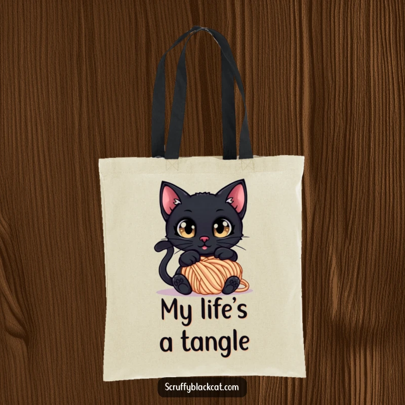 Funny Tote Bag: A black cat with wide, curious eyes tangled in a ball of yarn, perfect for carrying essentials.